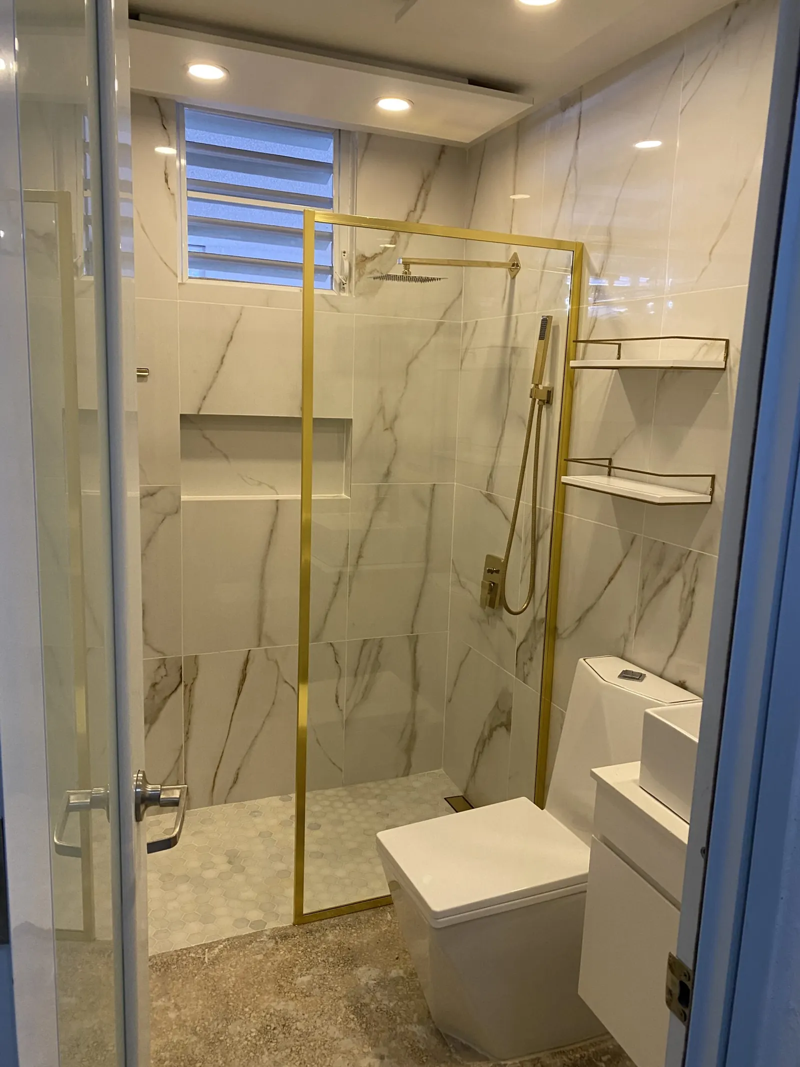 Bathroom with marble tile and a glass shower