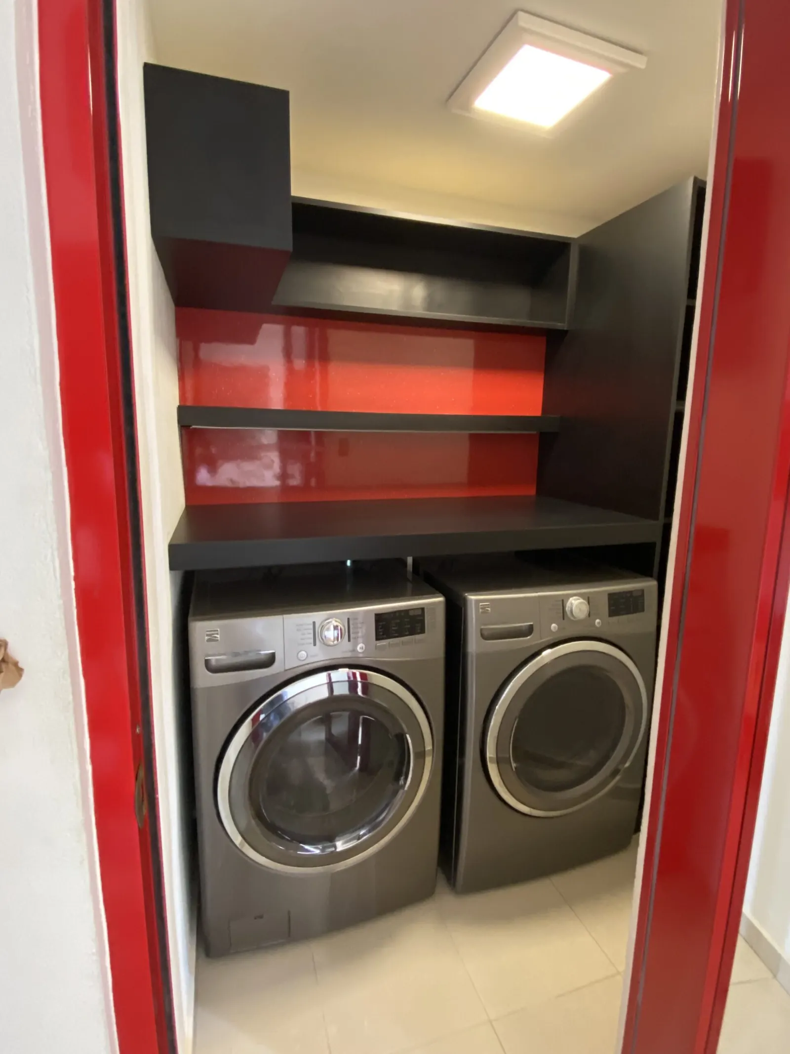 Laundry closet with red gloss cabinets