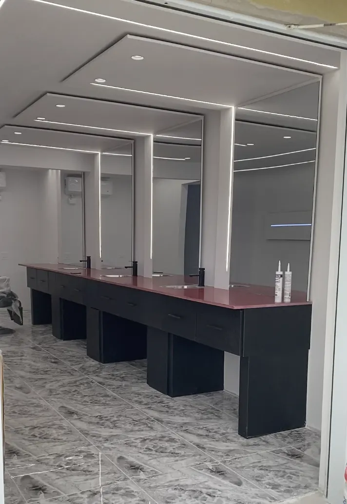 Commercial vanity stations with lit mirrors and a marble floor